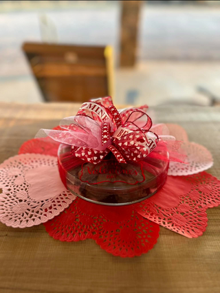 Decorative red flower arrangement on a wooden surface with blurred background