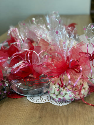 Baskets of candy with red ribbons on a wooden surface